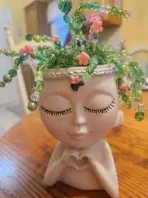 Face planter with beaded vine plant